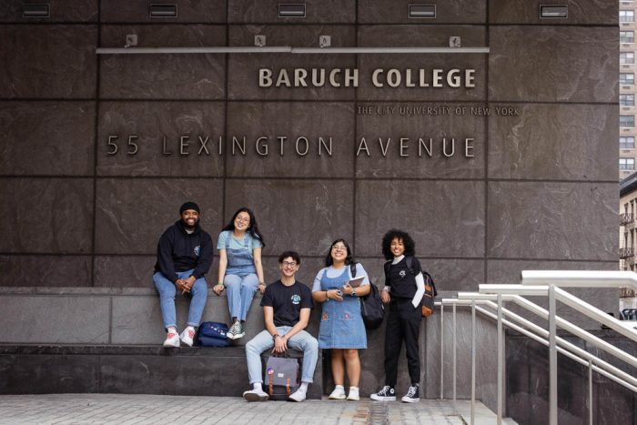 5 Baruch College students posing in front of a college building
